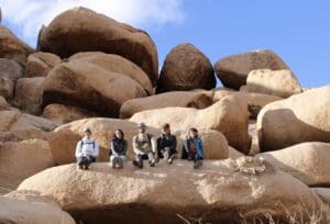 Five people sitting on the big rocks