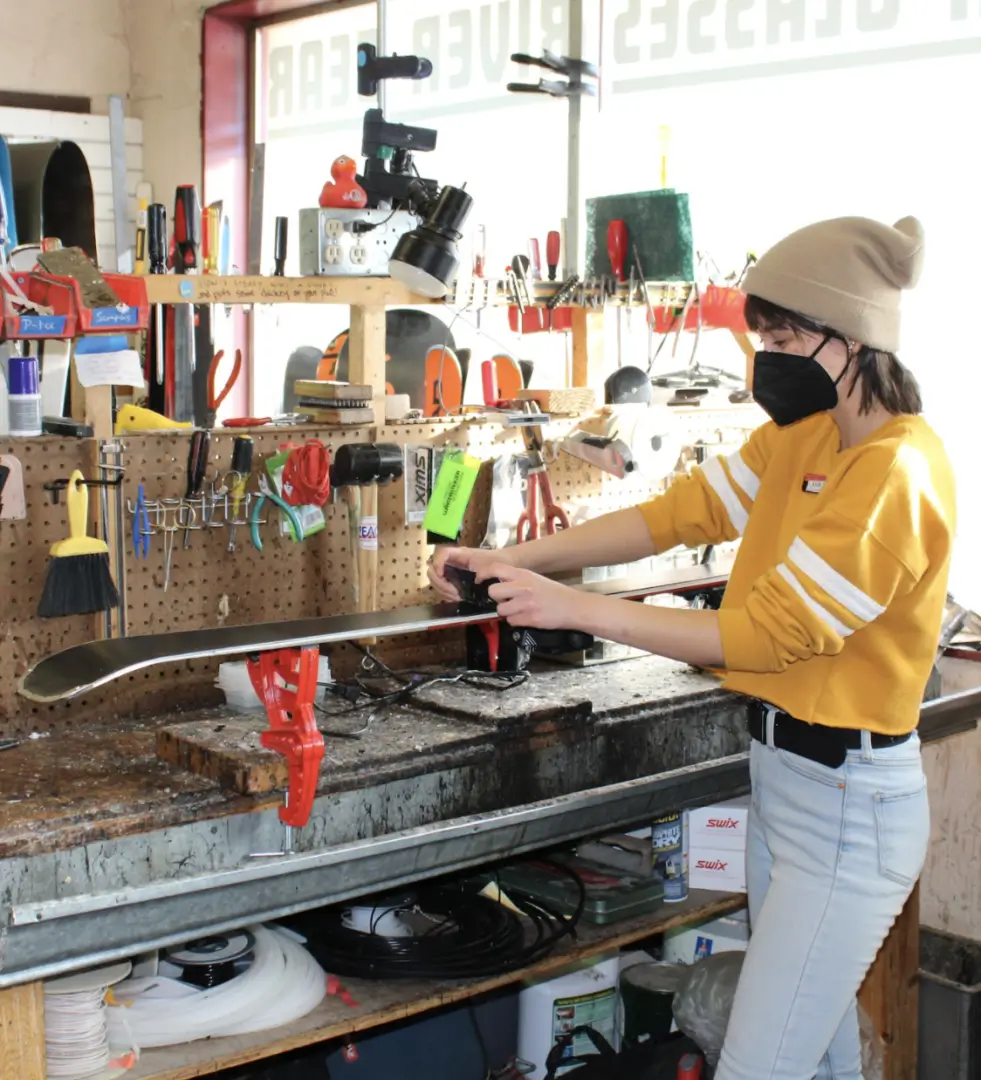 A woman wearing a mask and holding a stick.