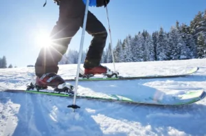 A person is skiing on the snow covered ground.