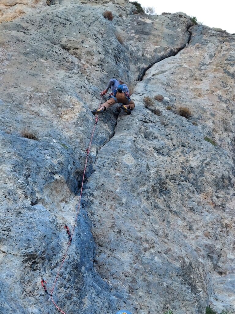 A man climbing up the side of a mountain.